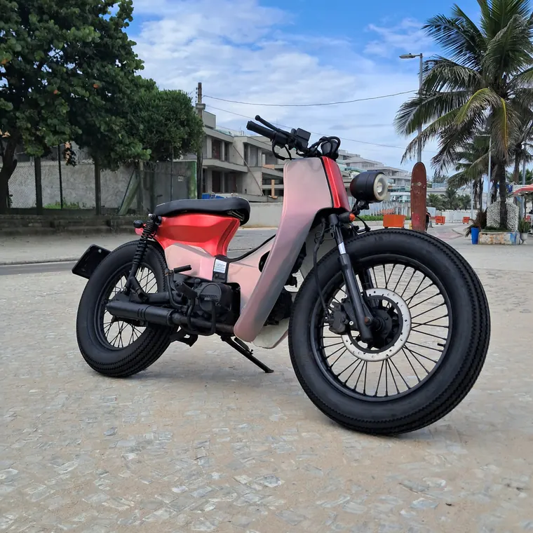 Custom pink-and-black motorcycle build parked by the beach