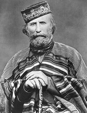 Black-and-white 1866 portrait photograph of Giuseppe Garibaldi seated, used as the reference for the illustrated gaucho's face