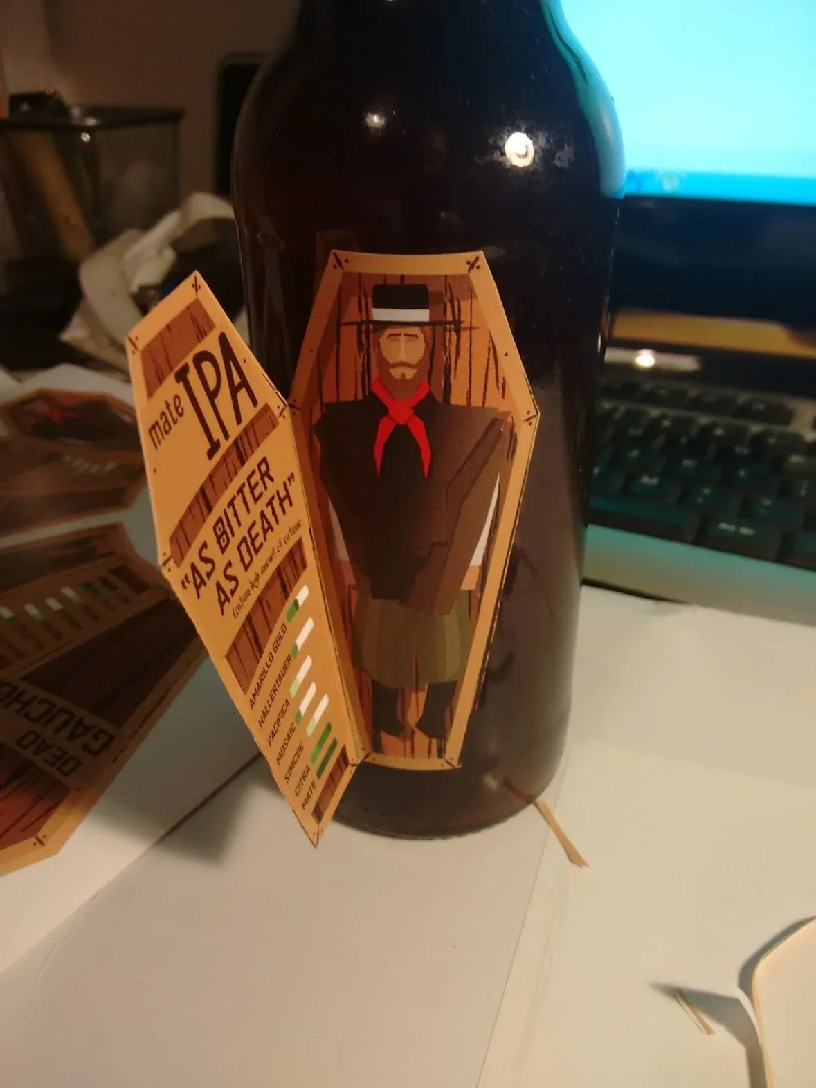 Photograph of the printed foldable label applied to an actual beer bottle, opened to reveal the gaucho illustration inside